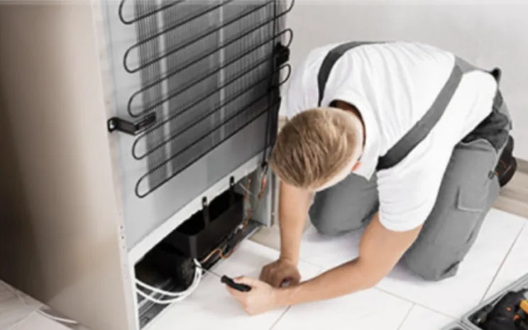 Engineer repairing a fridge freezer