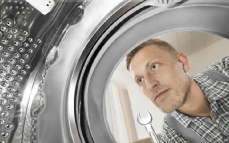 Engineer inspecting a tumble dryer drum
